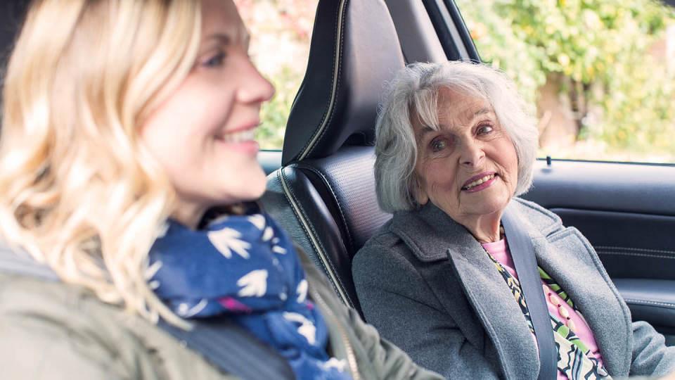 Woman and elderly passenger in car drive driving