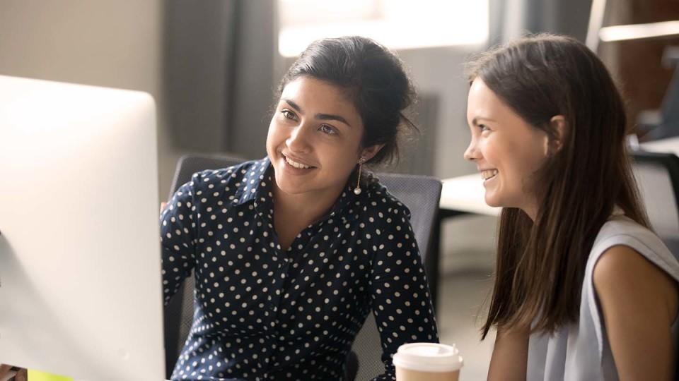 2 woman at laptop smiling