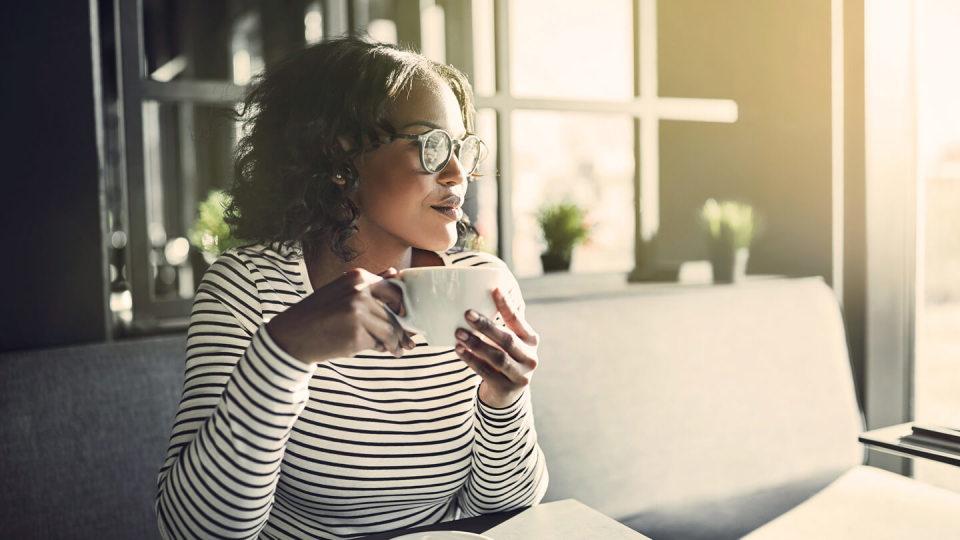 Young woman sat drinking a coffee