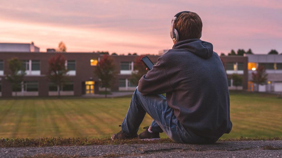 Young man sat looking at football field