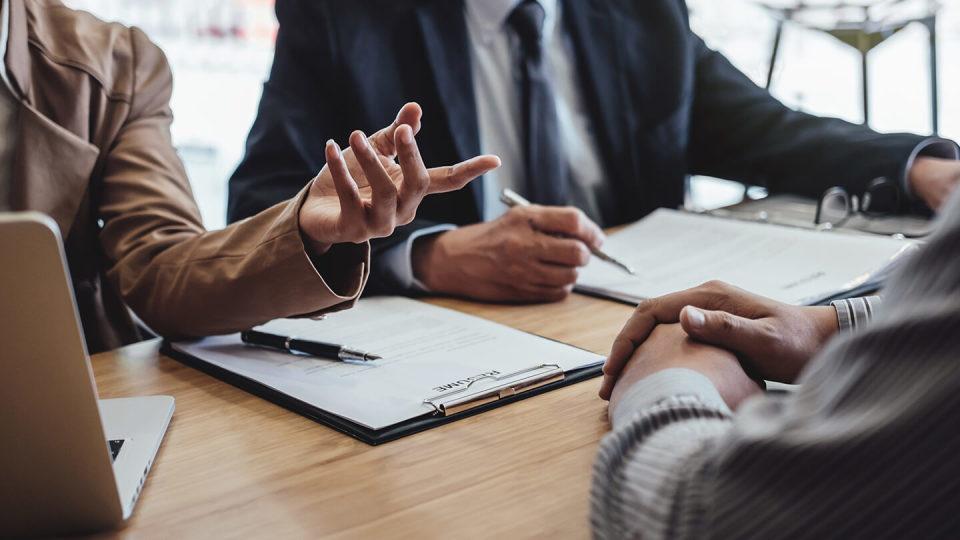 Two senior manager reading a resume during a job interview, Employer interviewing to ask young male job seeker for recruitment talking in office