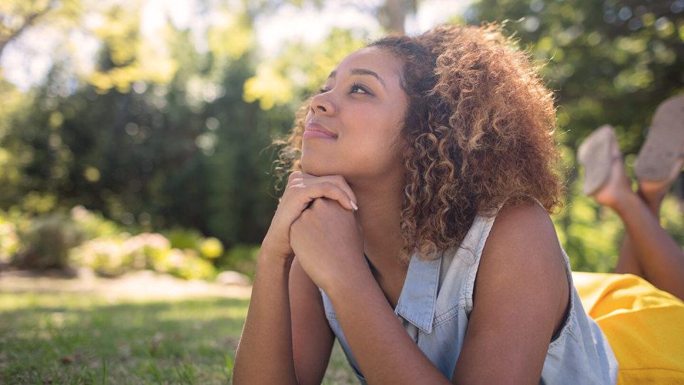 Young woman daydreaming in garden