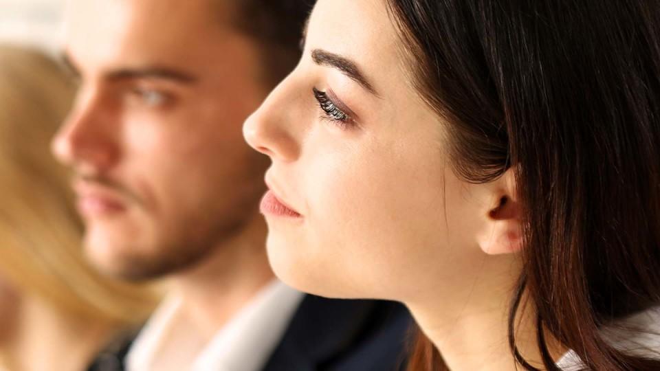 Woman listening to someone with man in background