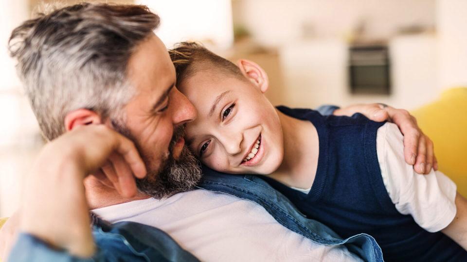 Father slouching and embracing son