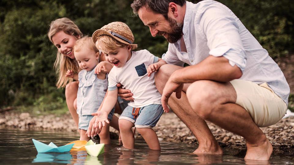 Young family with two children playing in the water