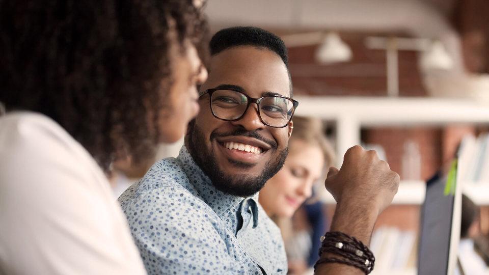 Man in glasses smiling at friend