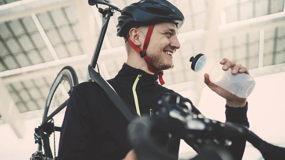 Cyclist - Man drinking water carrying bike