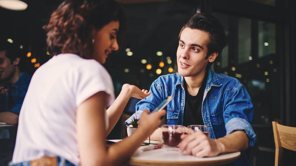 Young couple in cafe - woman on phone