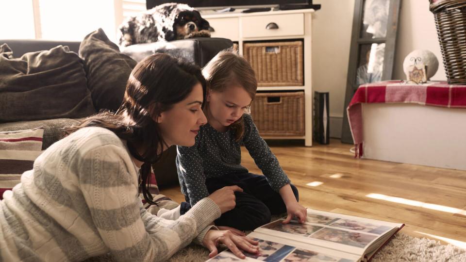 Mother and daughter looking at family photo album