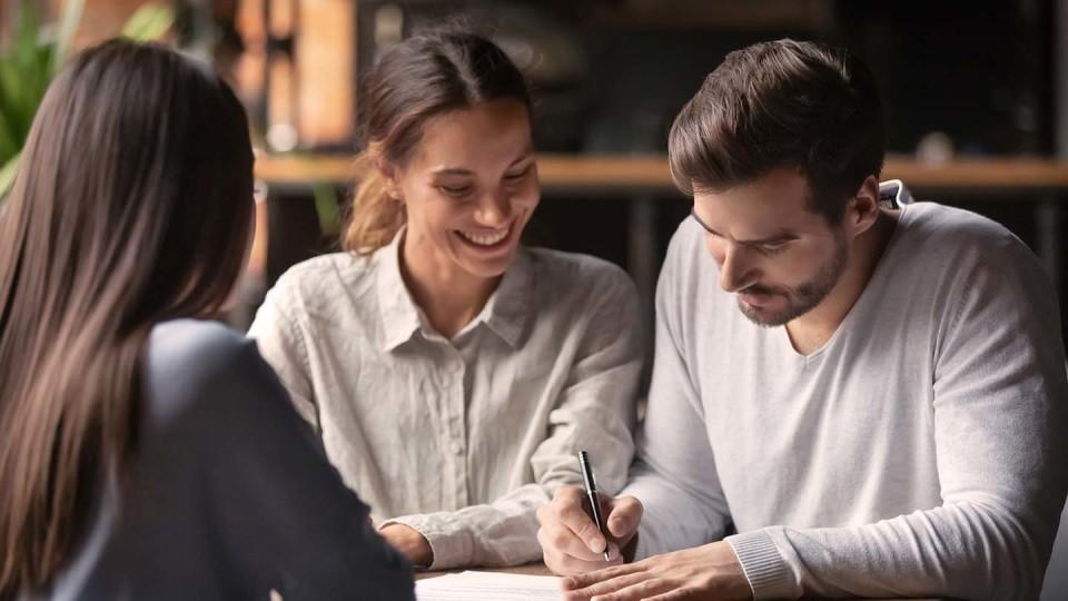 3 people signing a contract