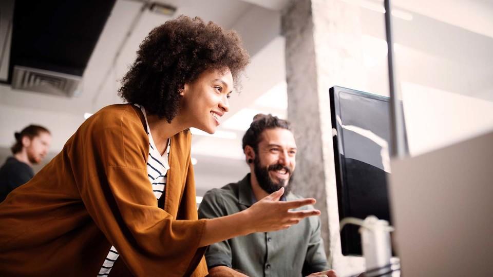 Man and woman in office looking at screen