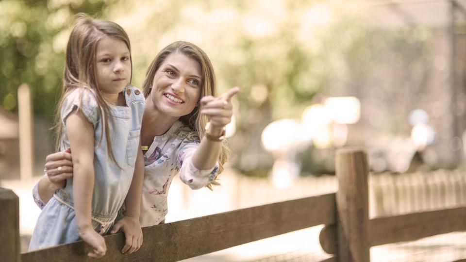 Mother and daughter outside looking at something