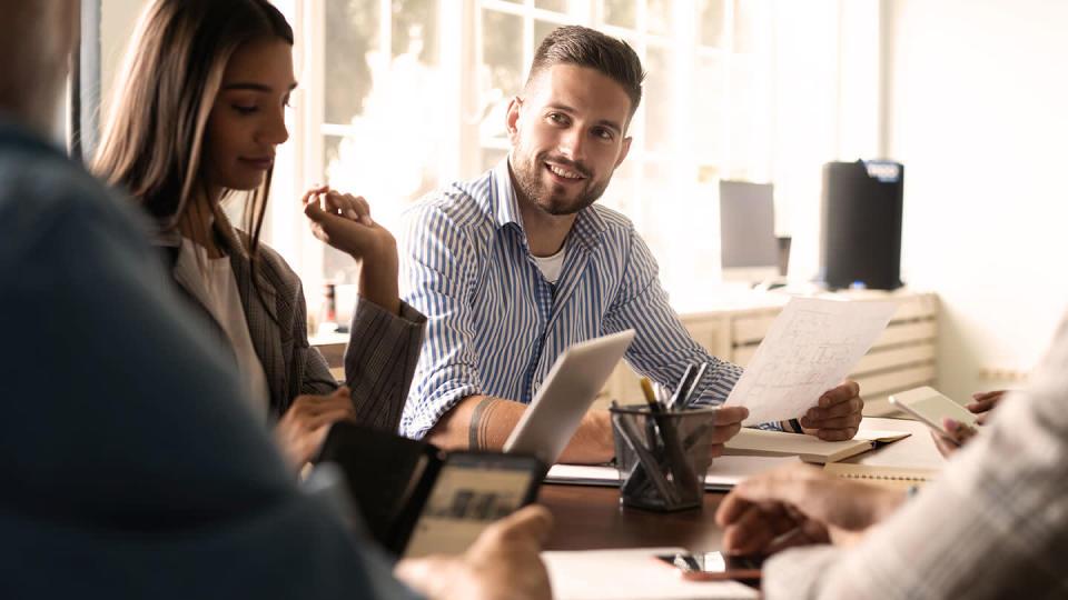 Man smiling with work colleagues